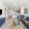 Living Room at One North of Boston with wall mounted TV, couch, and peninsula kitchen in the background